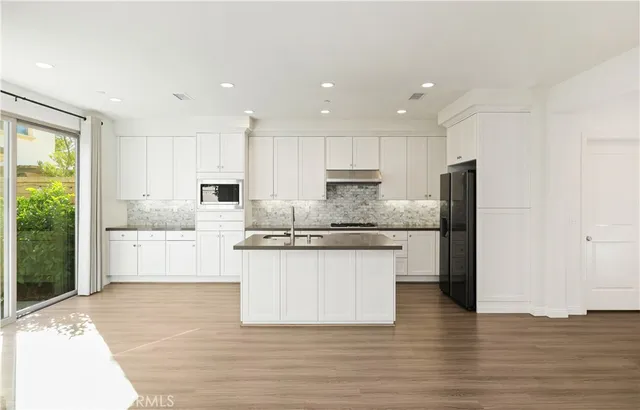 a large kitchen with granite countertop a large counter top stainless steel appliances and cabinets