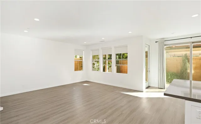 a view of a big room with wooden floor and windows