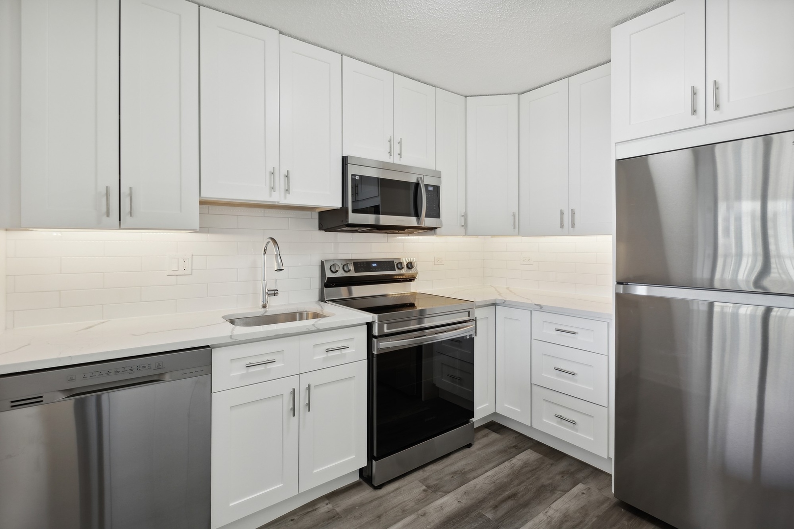 111 West Maple Street, Unit 1208 Chicago, IL 60610 - Photo 3 of 14 a kitchen with white cabinets and stainless steel appliances