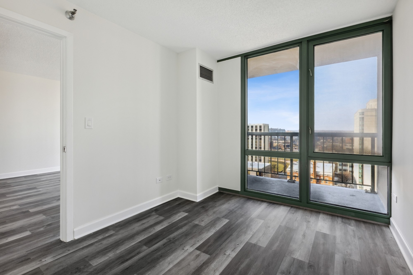 111 West Maple Street, Unit 1208 Chicago, IL 60610 - Photo 9 of 14 a view of an empty room with wooden floor and a window