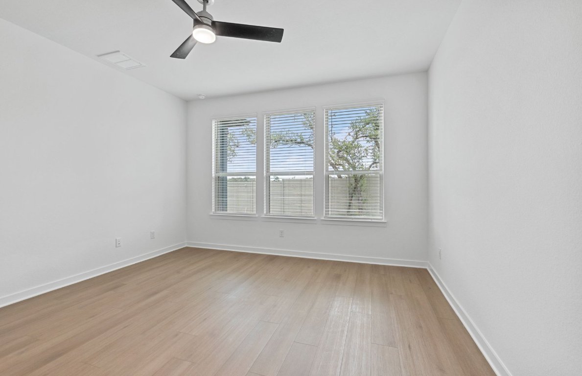 1700 Spg Mountain Cove Georgetown, TX 78628 - Photo 15 of 40 an empty room with wooden floor and windows