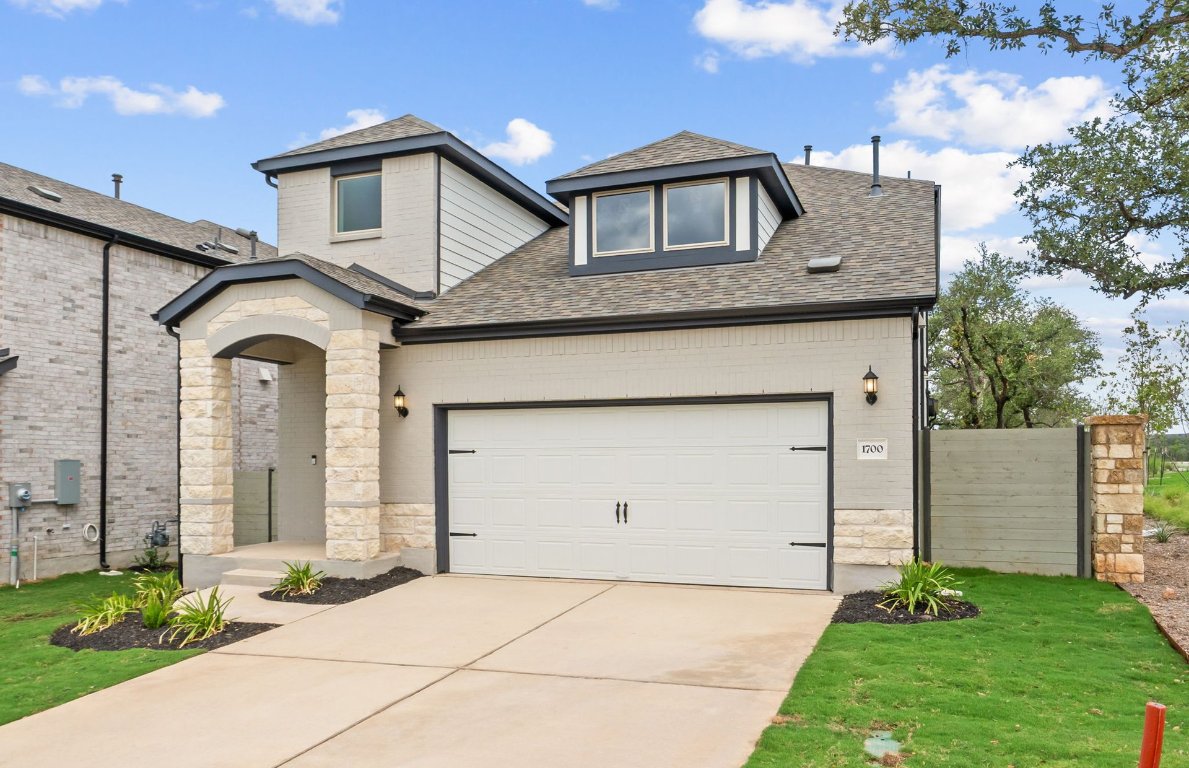 1700 Spg Mountain Cove Georgetown, TX 78628 - Photo 2 of 40 a front view of a house with a garden
