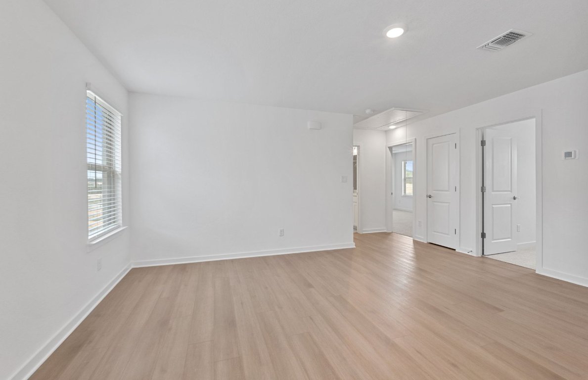1700 Spg Mountain Cove Georgetown, TX 78628 - Photo 22 of 40 an empty room with wooden floor and windows