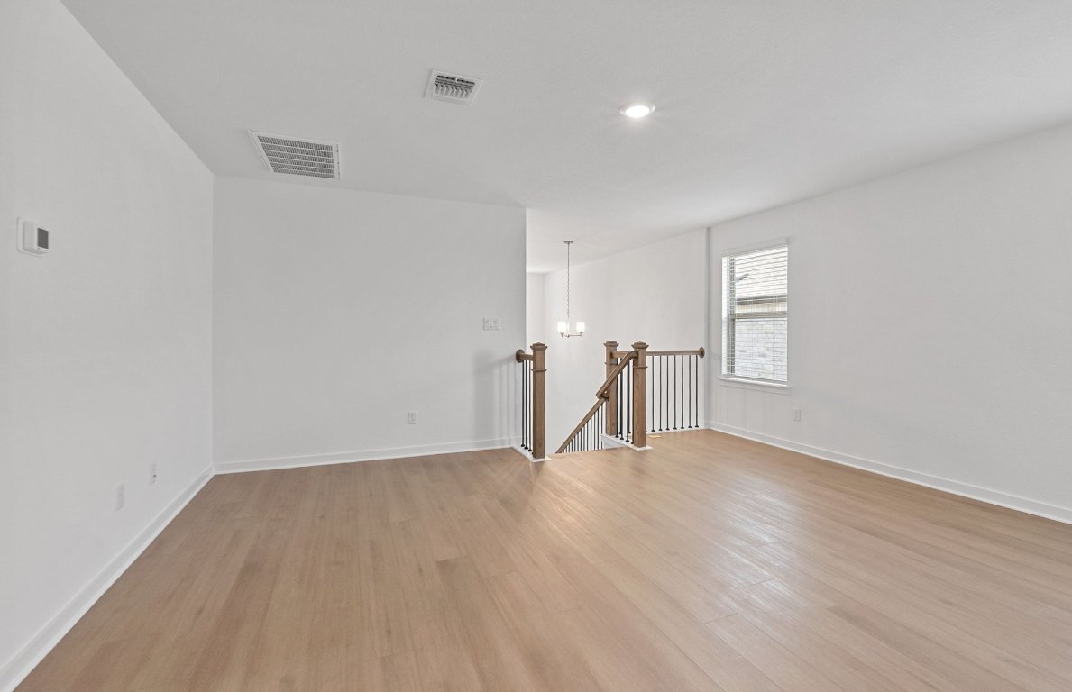 1700 Spg Mountain Cove Georgetown, TX 78628 - Photo 23 of 40 a view of an empty room with wooden floor and a window