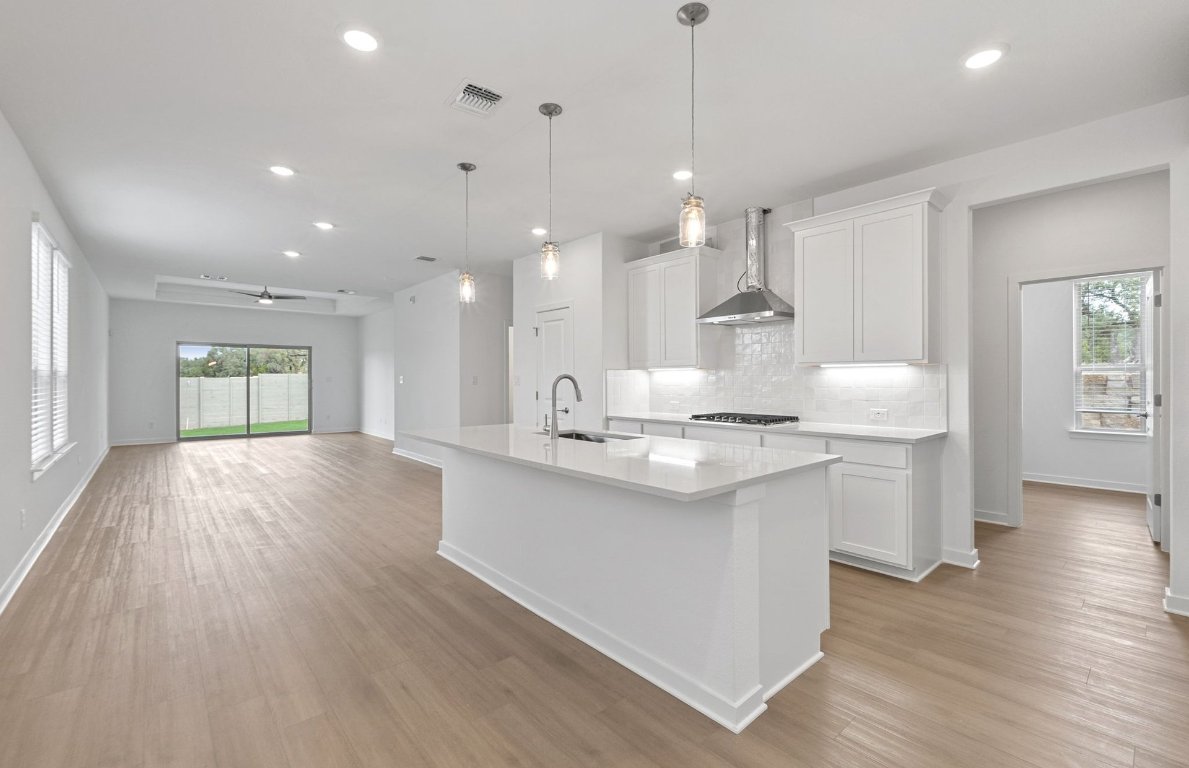 1700 Spg Mountain Cove Georgetown, TX 78628 - Photo 6 of 40 a kitchen with kitchen island a sink and a stove top oven