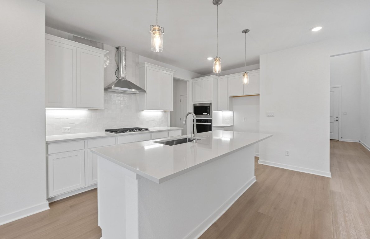 1700 Spg Mountain Cove Georgetown, TX 78628 - Photo 8 of 40 a kitchen with kitchen island a sink counter top space a stove and cabinets