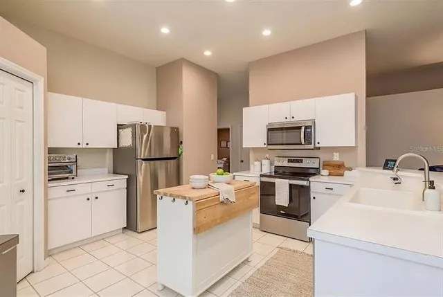 a kitchen with white cabinets and stainless steel appliances