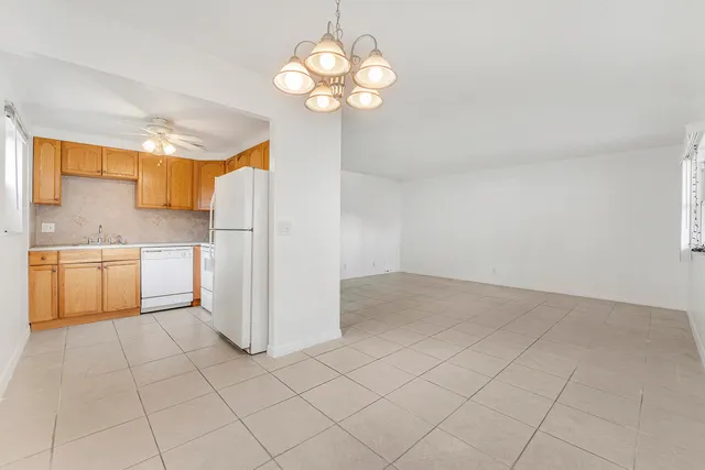 an empty room with chandelier fan