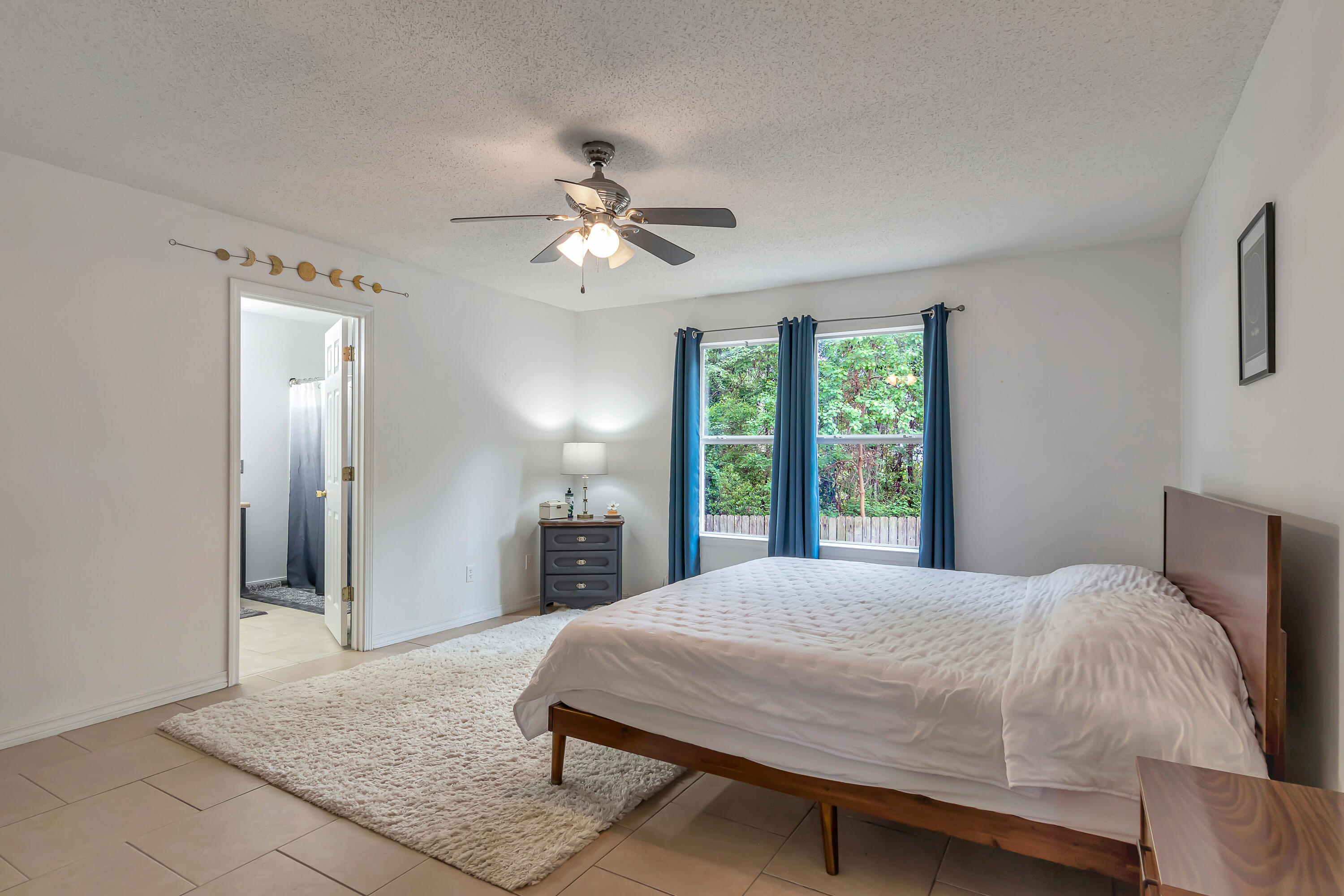 270 Limestone Circle Crestview, FL 32539 - Photo 18 of 35 a bedroom with a large bed a chandelier and window