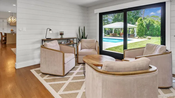 a living room with furniture and a floor to ceiling window