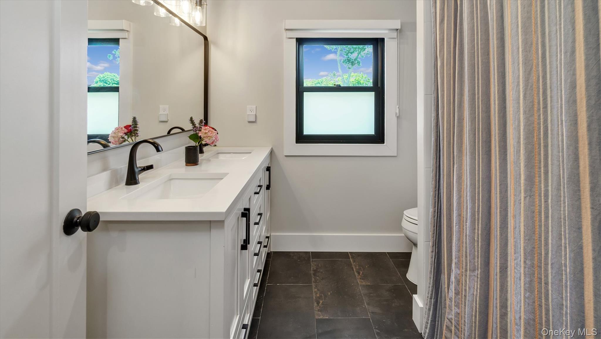 99 Beach Road Westhampton Beach, NY 11978 - Photo 25 of 37 a bathroom with a sink a toilet and a mirror