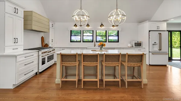 a kitchen with cabinets wooden floor dining table and chairs