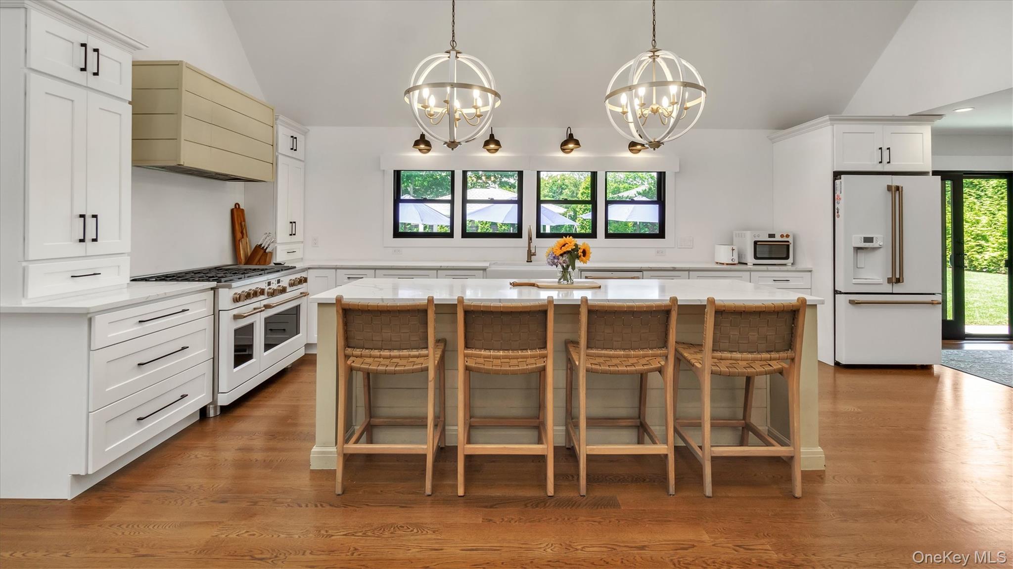 99 Beach Road Westhampton Beach, NY 11978 - Photo 8 of 37 a kitchen with cabinets wooden floor dining table and chairs