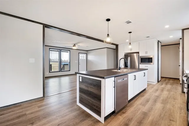 a kitchen with stainless steel appliances granite countertop a kitchen island a stove a sink dishwasher and a refrigerator