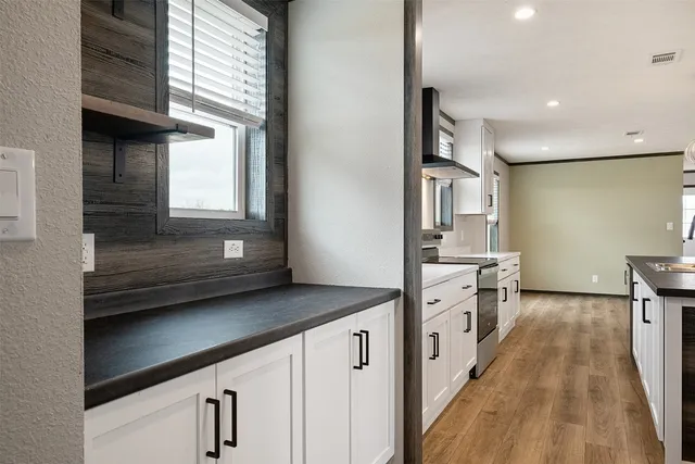 a large kitchen with stainless steel appliances granite countertop a stove and a refrigerator