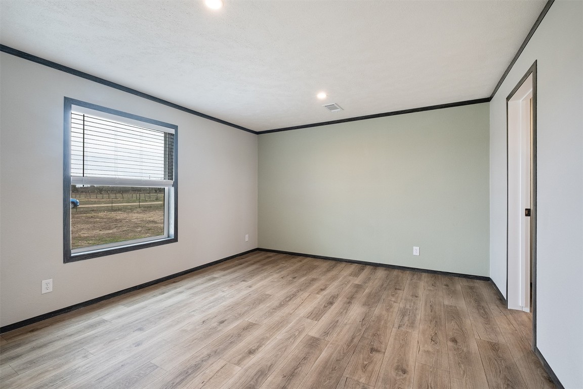 339 Lower Red Rock Road Bastrop, TX 78602 - Photo 19 of 29 a view of an empty room with wooden floor and a window