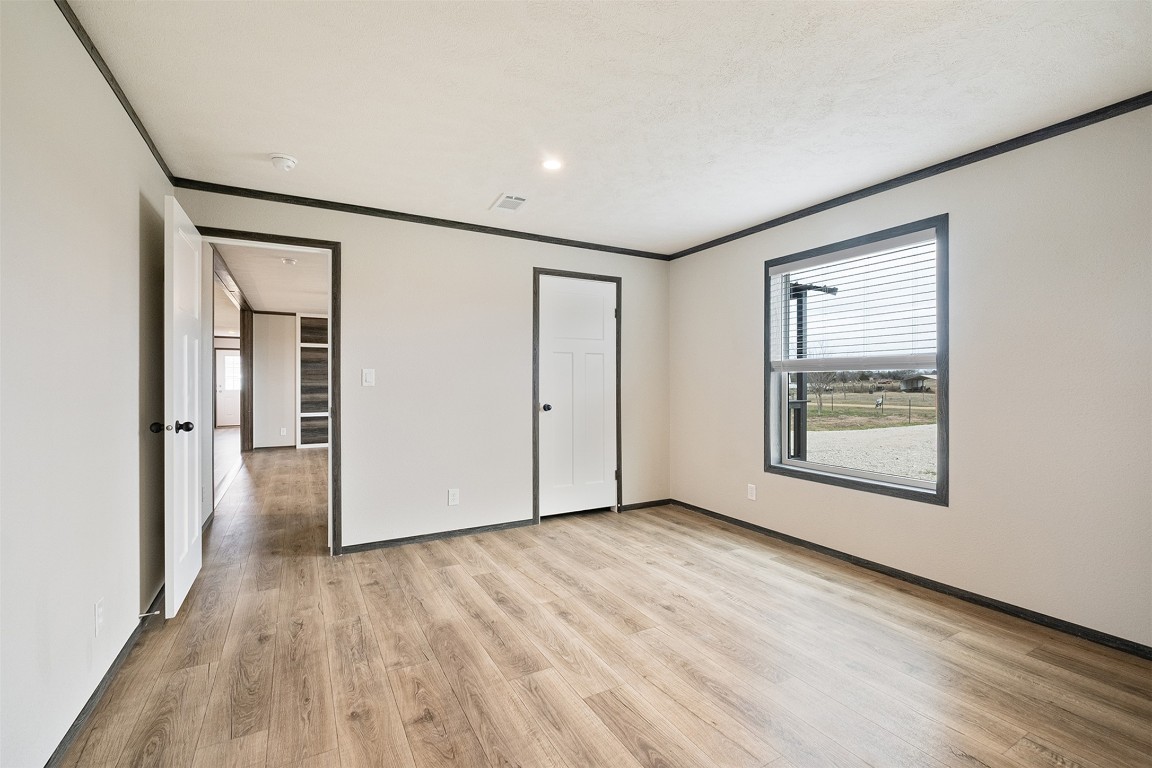 339 Lower Red Rock Road Bastrop, TX 78602 - Photo 21 of 29 a view of an empty room with wooden floor and a window