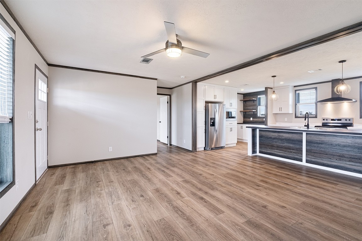 339 Lower Red Rock Road Bastrop, TX 78602 - Photo 7 of 29 a view of a kitchen with wooden floor and a refrigerator