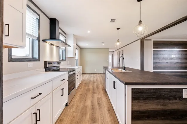 a kitchen with counter top space stainless steel appliances and wooden floor