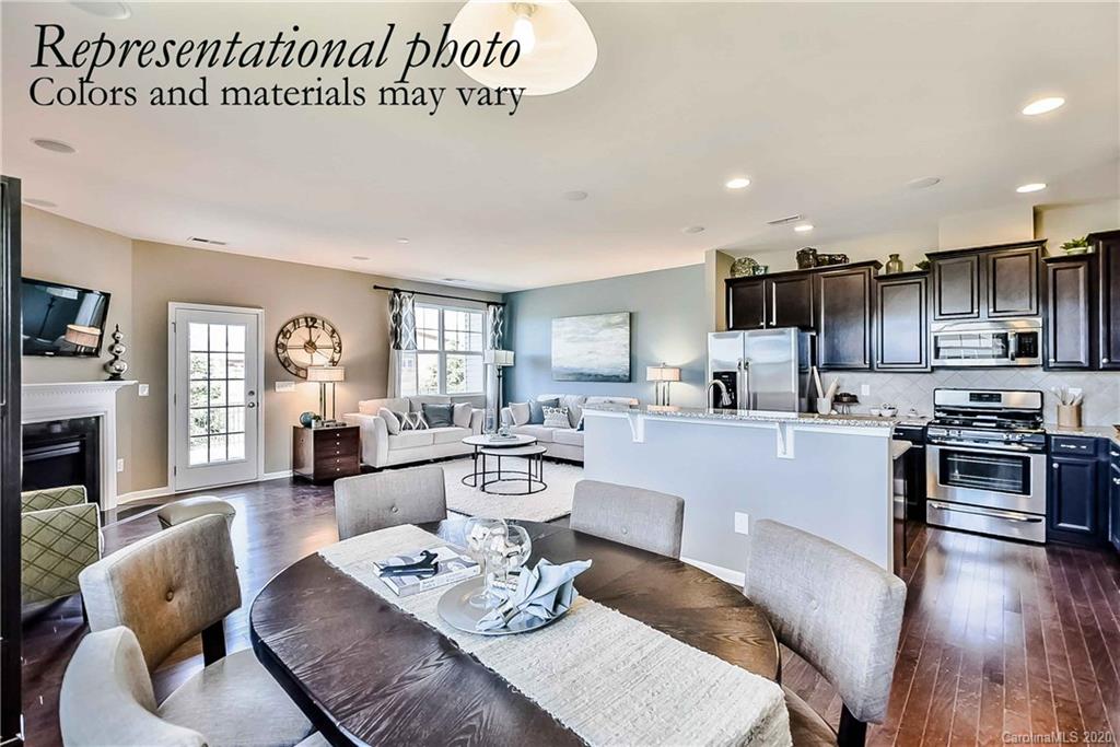 1633 Corwin Bend Road Tega Cay, SC 29708 - Photo 7 of 10 a open kitchen with stainless steel appliances granite countertop a stove a sink a dining table and chairs with wooden floor