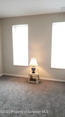 a view of an empty room with closet and a window