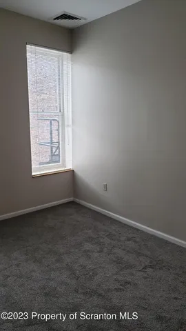 a white toilet sitting next to a white wall