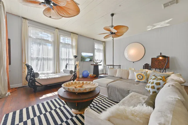 a living room with furniture a chandelier and a large window