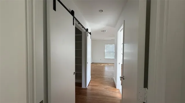 a view of hallway with wooden floor