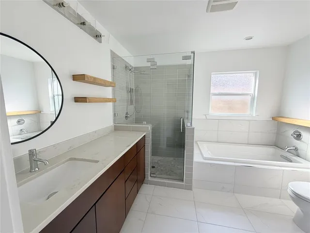a bathroom with a tub sink and mirror