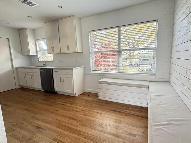 a view of a kitchen with wooden floor and electronic appliances