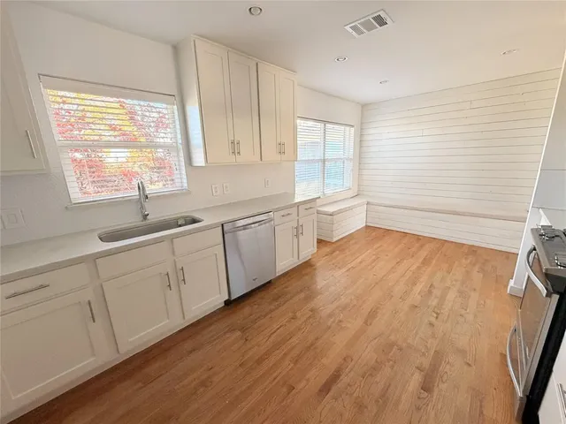 a view of a kitchen with wooden floor and a window