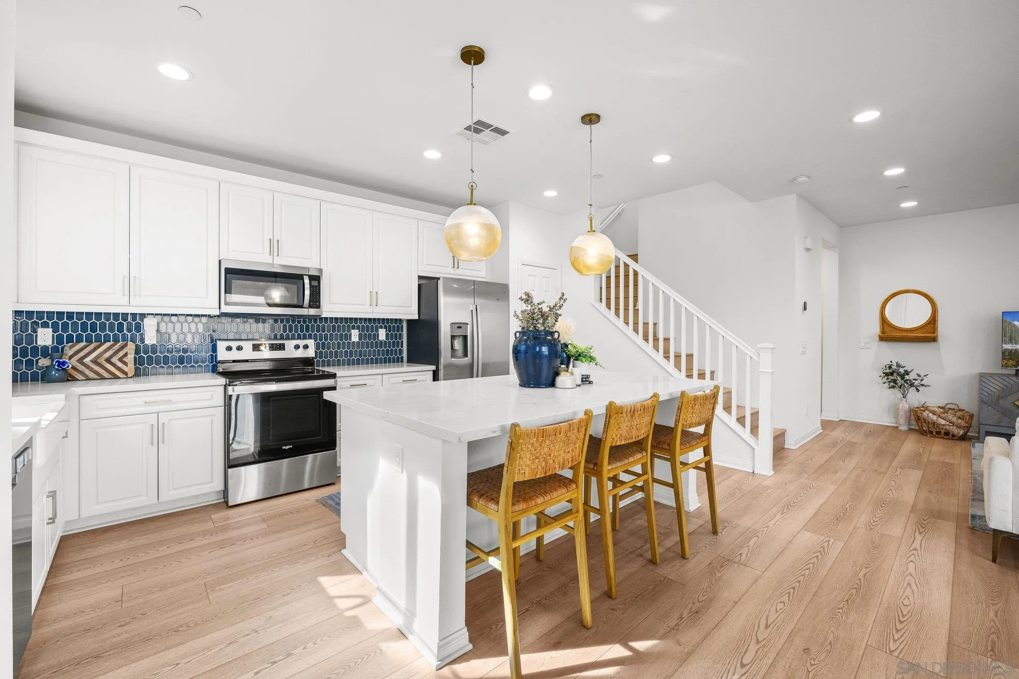 2612 Babaco Street Spring Valley, CA 91977 - Photo 13 of 37 a kitchen with stainless steel appliances kitchen island granite countertop a stove a sink a refrigerator and a dining table with wooden floor