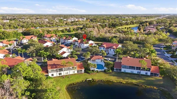 an aerial view of residential houses with outdoor space and trees