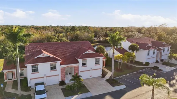 an aerial view of residential houses with outdoor space and trees