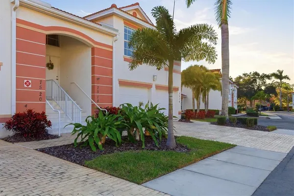 a front view of a house with a yard and potted plants