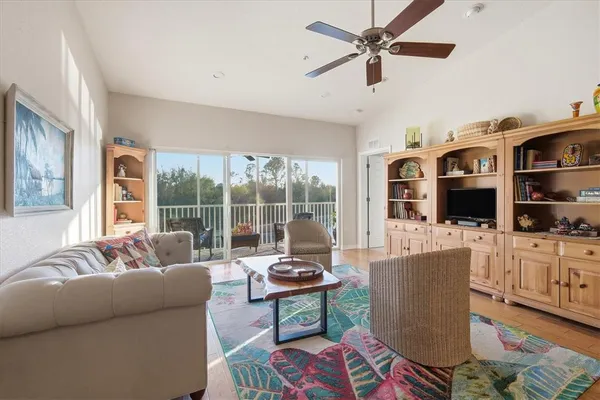 a living room with furniture a flat screen tv and a large window