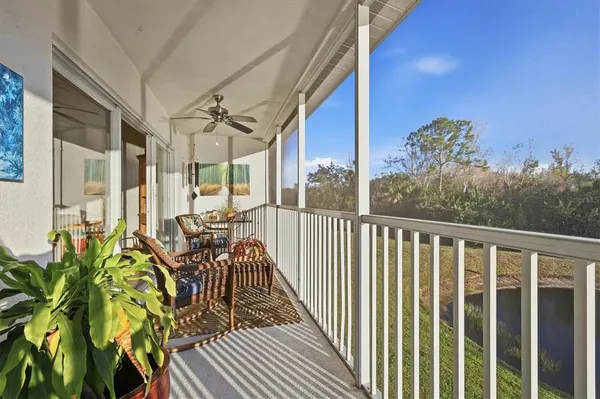 a balcony with wooden floor table and chairs