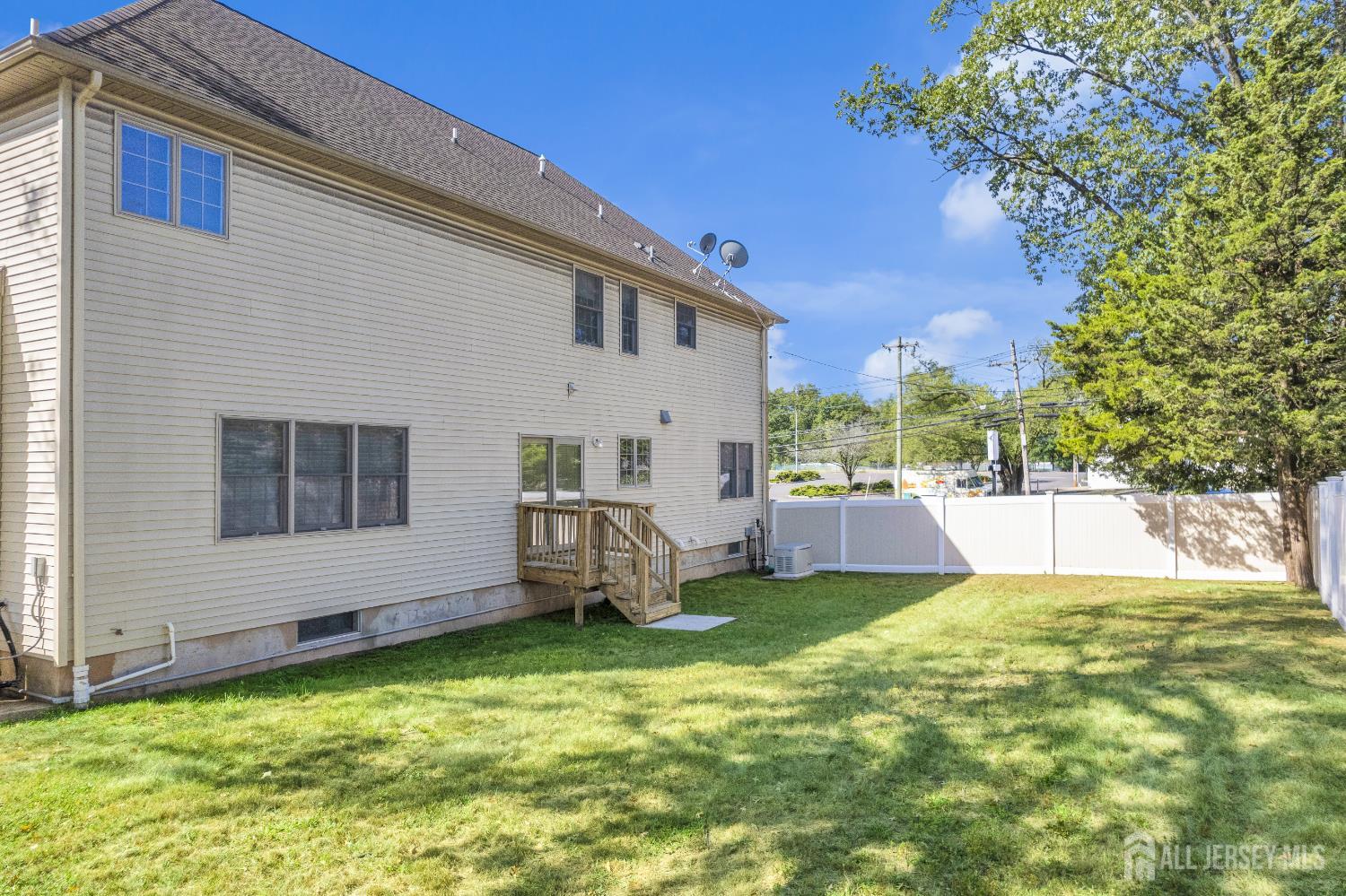 114 Holly Road Iselin, NJ 08830 - Photo 44 of 47 a view of a white house with a big yard potted plants and a large tree