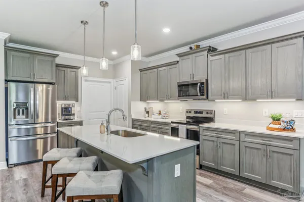 a kitchen with stainless steel appliances granite countertop a sink a stove and a refrigerator