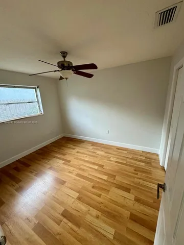 a view of a room with wooden floor and white walls