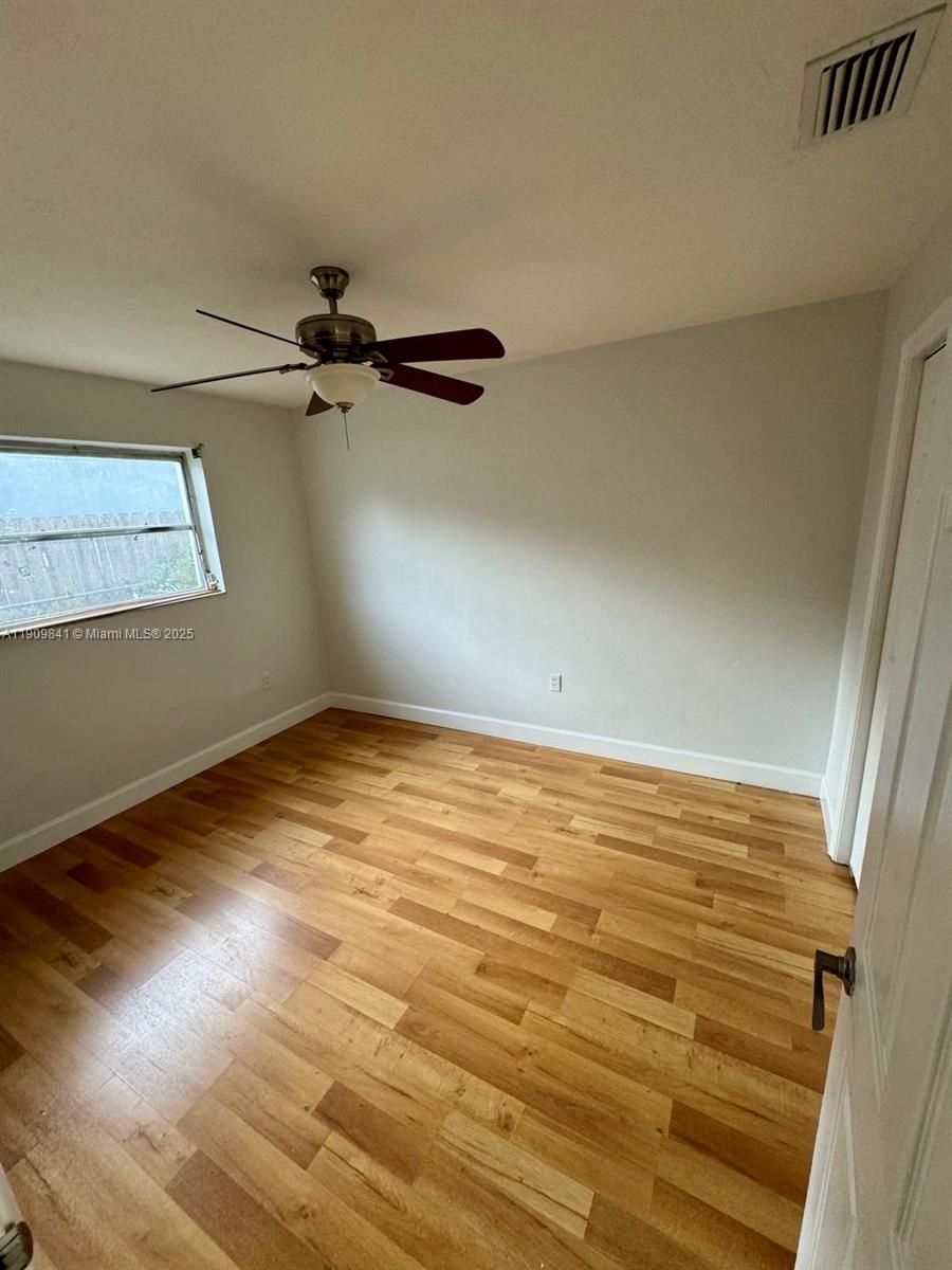 8670 Northwest 28th Place Sunrise, FL 33322 - Photo 8 of 13 a view of a room with wooden floor and white walls