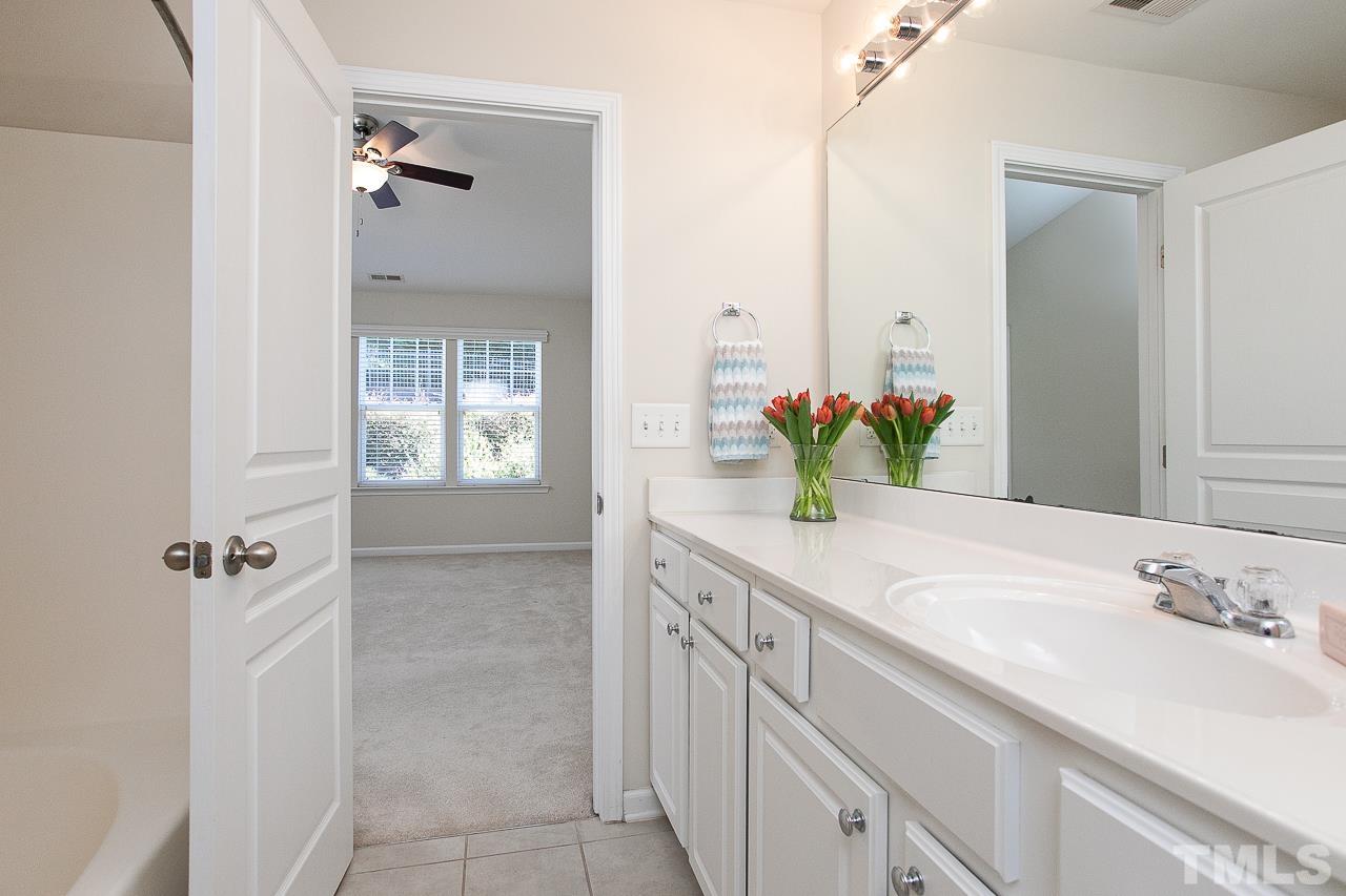 6016 Viking Drive Raleigh, NC 27612 - Photo 12 of 18 a bathroom with a granite countertop sink a mirror and a shower