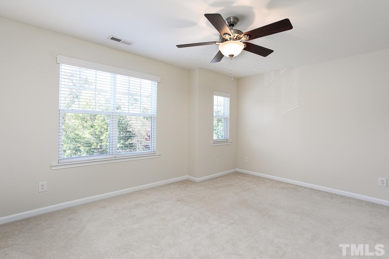 6016 Viking Drive Raleigh, NC 27612 - Photo 13 of 18 an empty room with windows and ceiling fan