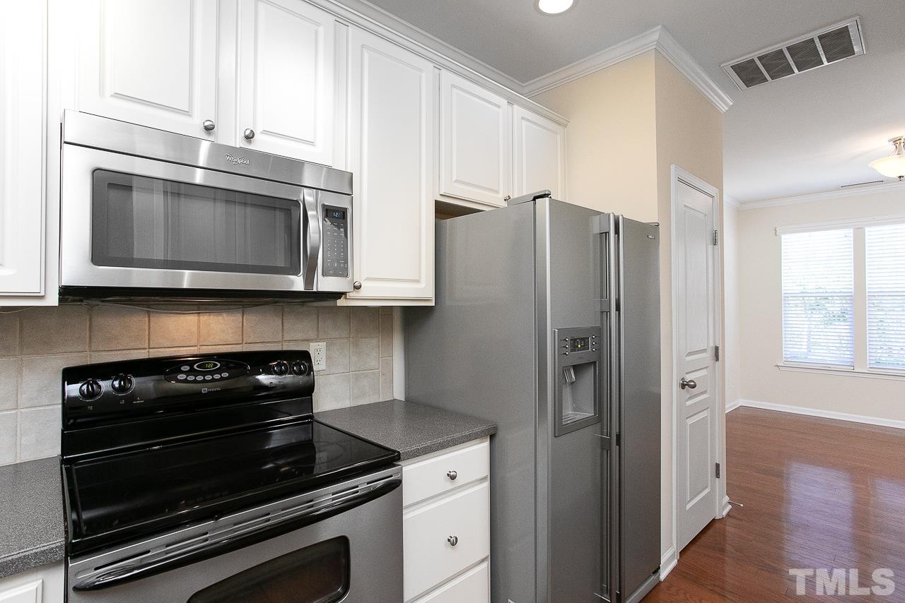 6016 Viking Drive Raleigh, NC 27612 - Photo 3 of 18 a kitchen with stainless steel appliances a stove a microwave and a counter space