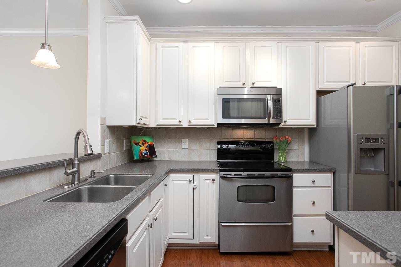 6016 Viking Drive Raleigh, NC 27612 - Photo 4 of 18 a kitchen with stainless steel appliances granite countertop a sink a stove and a microwave