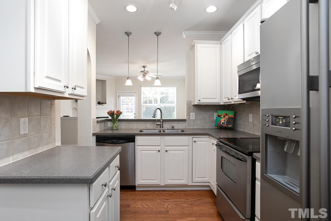 6016 Viking Drive Raleigh, NC 27612 - Photo 5 of 18 a kitchen with stainless steel appliances granite countertop a sink a stove and a refrigerator