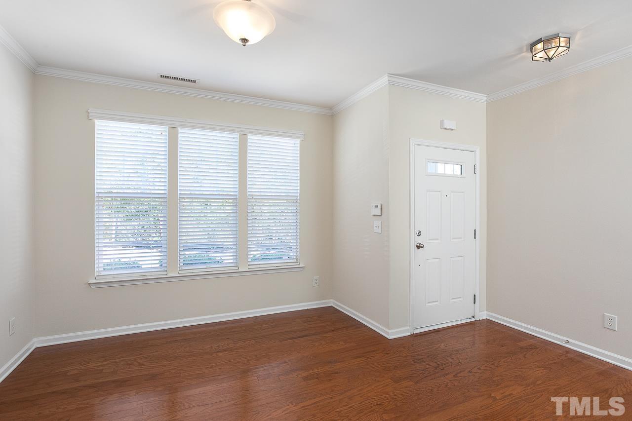 6016 Viking Drive Raleigh, NC 27612 - Photo 7 of 18 an empty room with wooden floor and windows