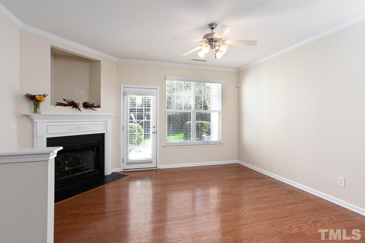 6016 Viking Drive Raleigh, NC 27612 - Photo 8 of 18 a view of an empty room with wooden floor and fireplace