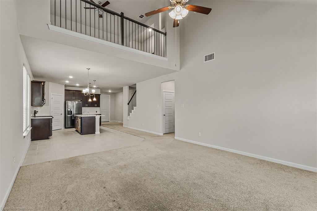 638 Pinehurst Road Red Oak, TX 75154 - Photo 32 of 38 Unfurnished living room featuring light colored carpet, ceiling fan, a high ceiling, and suspended lighting