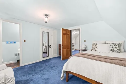a spacious bedroom with a bed next to a window with a flat screen tv